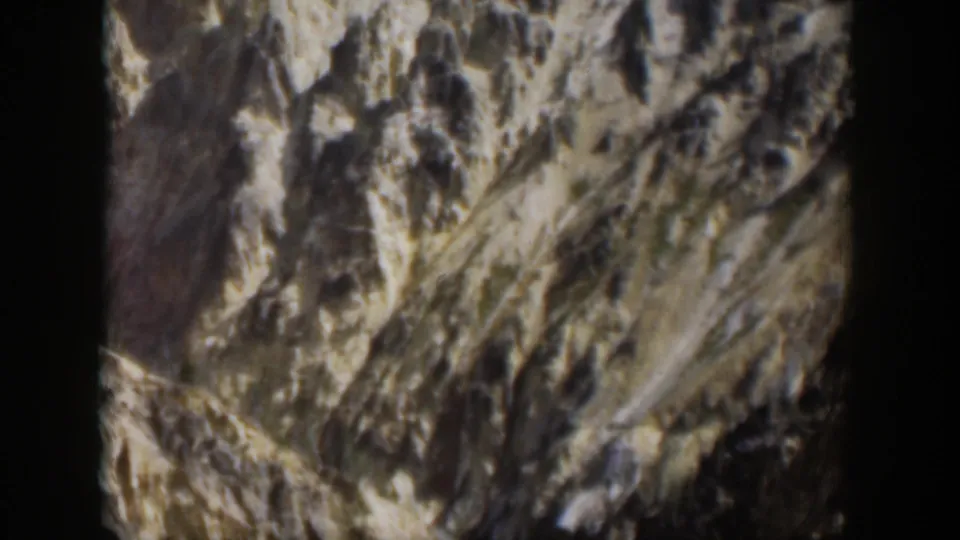 1951 Wyoming 8mm view of a rugged valley, steep eroded rock, and a faint stream below.