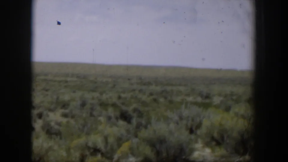 1951 Wyoming 8mm view across an open sagebrush plain, with a low horizon and pale blue sky.