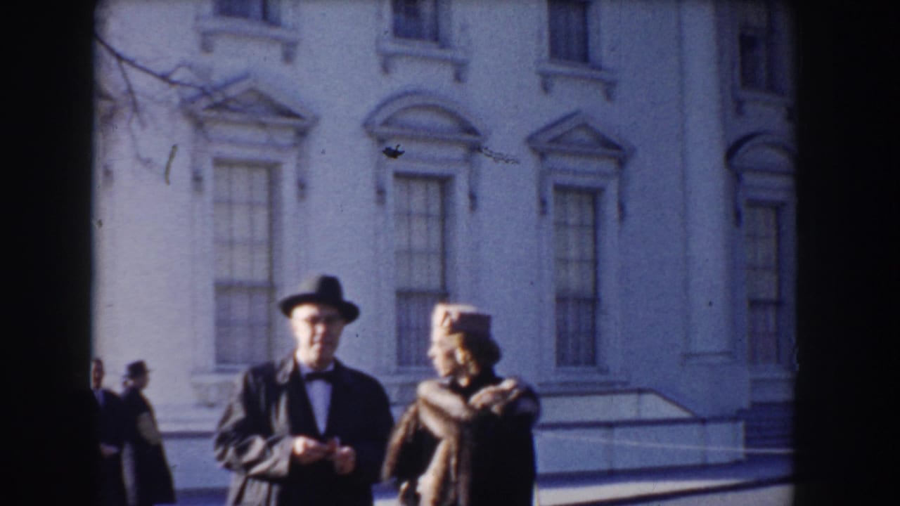 Man and woman standing in front of the White House facade.