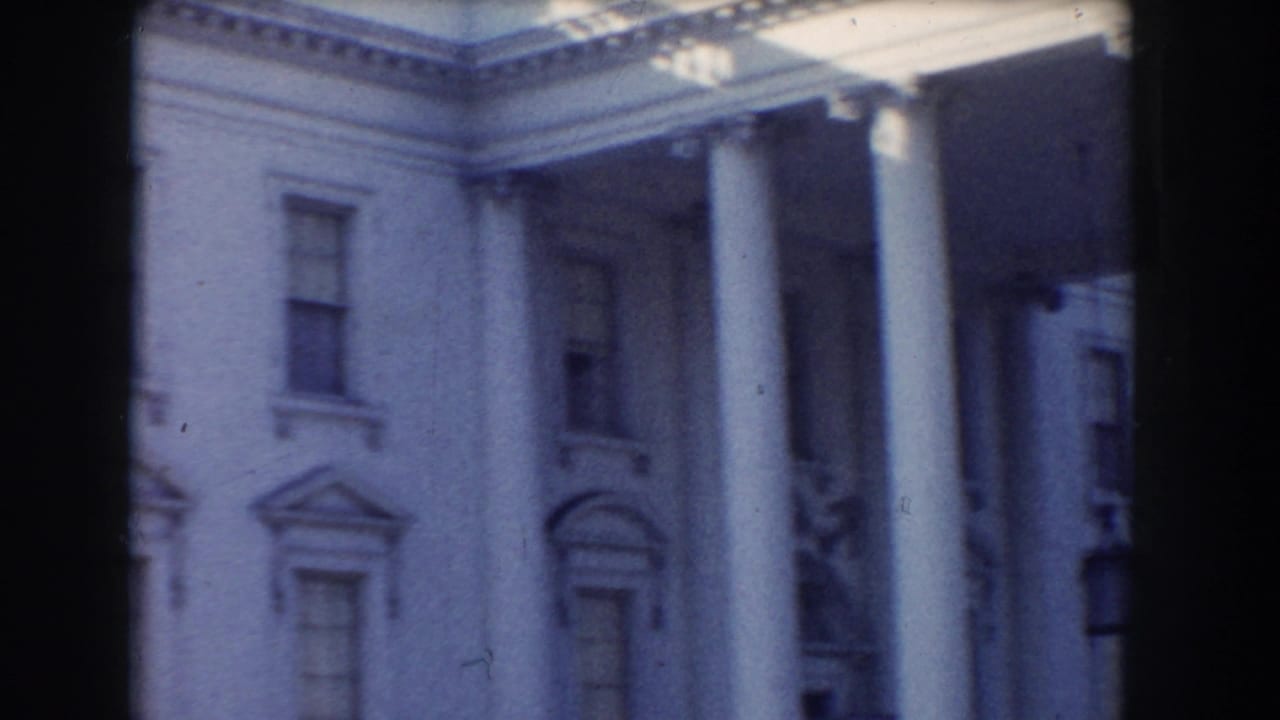 White House portico and facade seen through a dark film-frame divider.