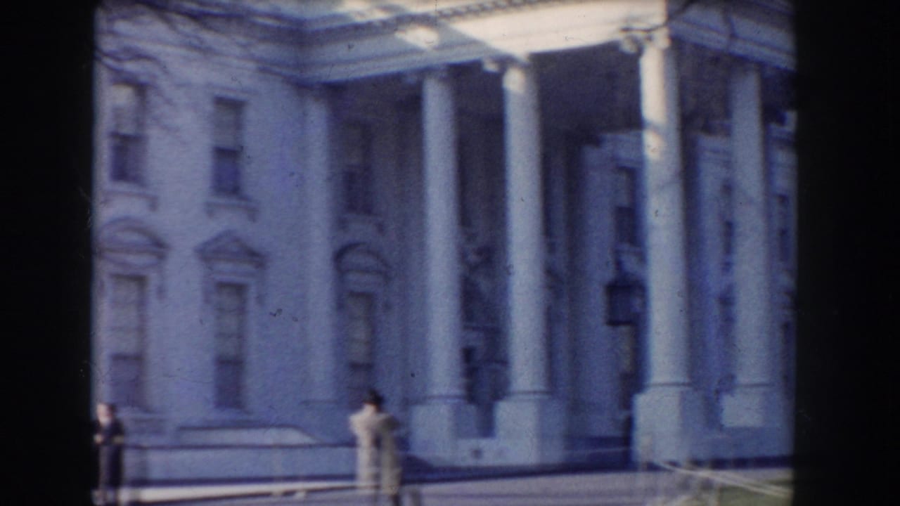 White House portico and facade with distant pedestrians on the walkway.