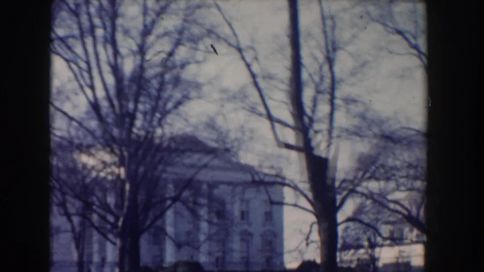 1960 Washington, DC frame showing the White House in the distance through leafless trees from Lafayette Square.