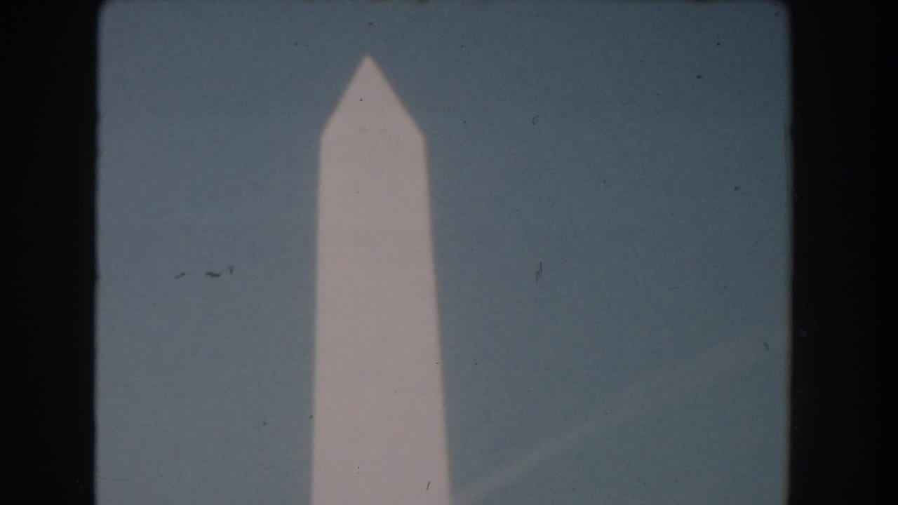 The pointed top of the Washington Monument appears centered in a 1960 Washington DC 8mm frame with visible film grain.