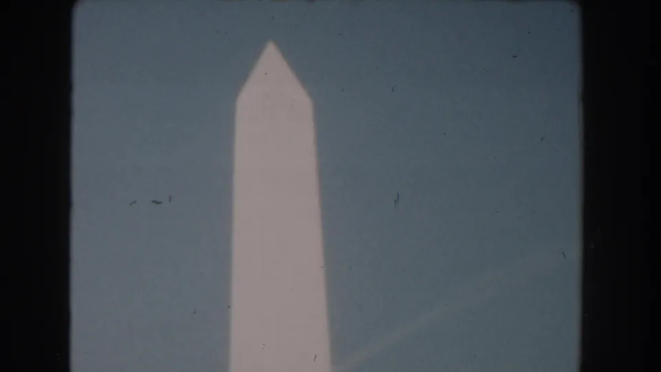 The pointed top of the Washington Monument appears centered in a 1960 Washington DC 8mm frame with visible film grain.