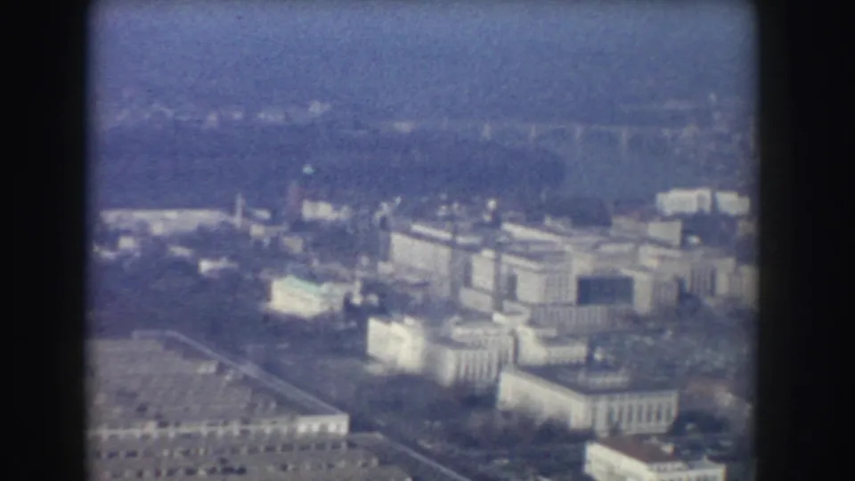 1960 aerial home-movie frame showing institutional buildings and grounds near the National Mall in Washington, DC.