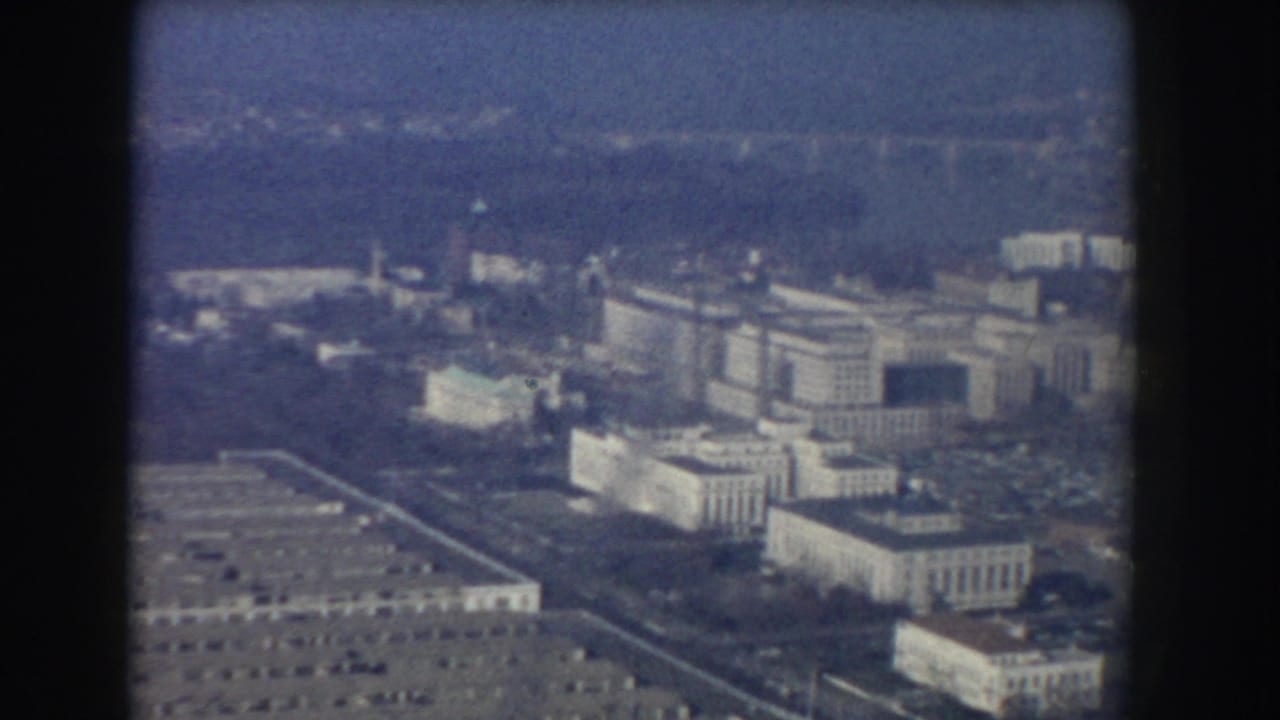 Aerial view of Washington, DC government buildings through dark aircraft-window edges.