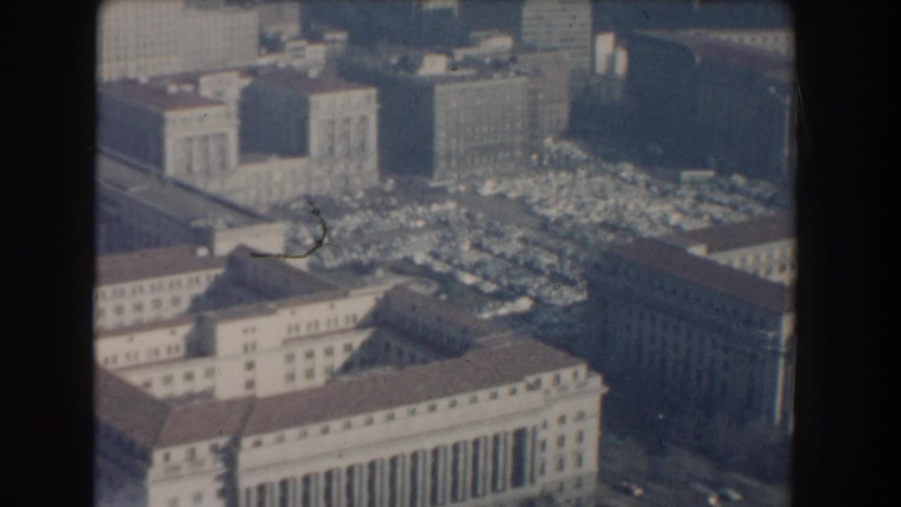 1960 Washington, DC aerial view with classical government-style facades, dense parking areas, rooftops, and streets.