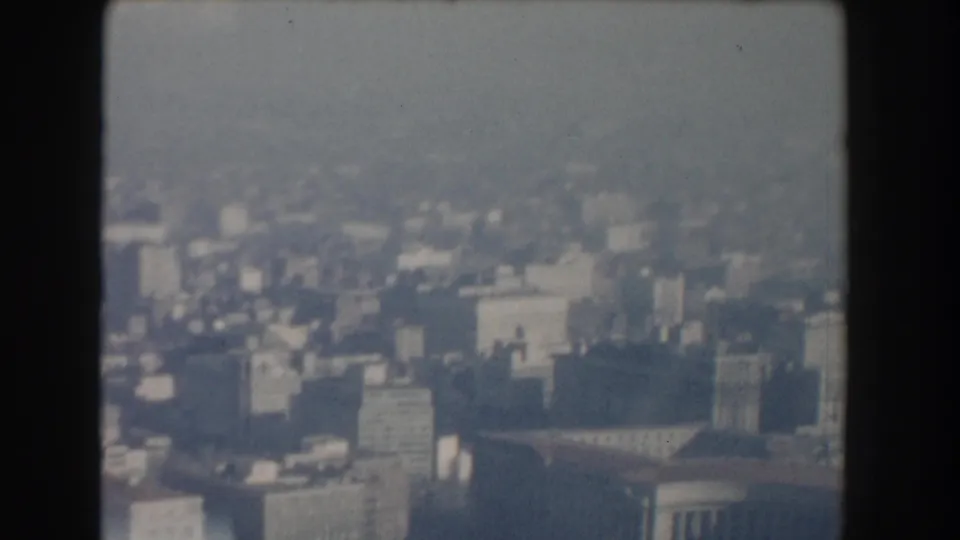 1960 Washington, DC aerial home-movie view looking across hazy downtown blocks and distant buildings.