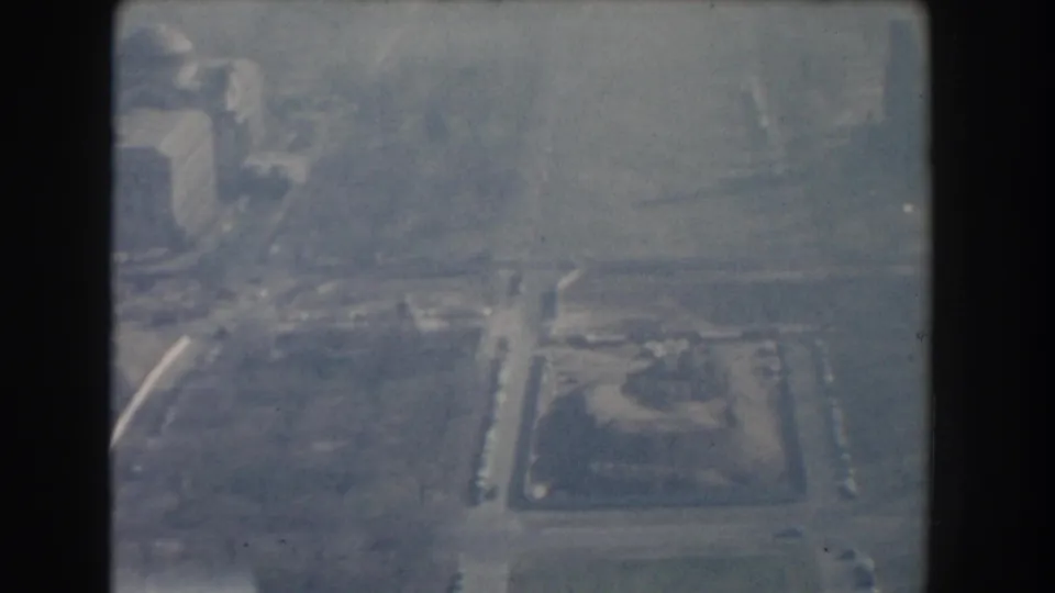 Hazy 1960 Washington, DC high-angle view with roads, a small landscaped area, and pale buildings softened by film exposure.