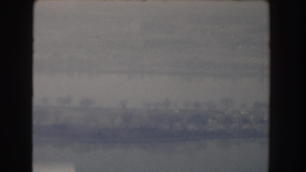 Hazy distant landscape or skyline seen through a dark film-frame border.