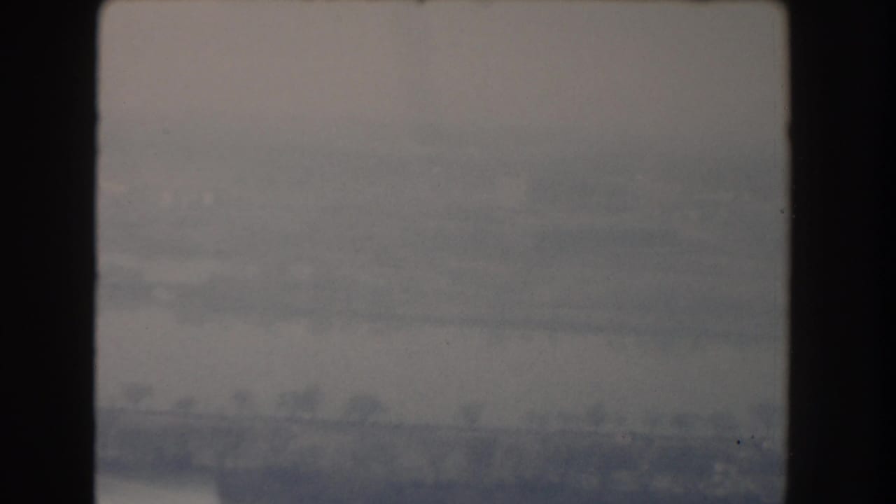 Soft distant horizon with haze and dark vertical film border at left.