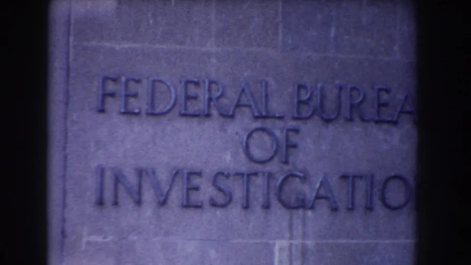 Close 1960 Washington, DC home-movie view of engraved Federal Bureau of Investigation lettering on a stone wall.