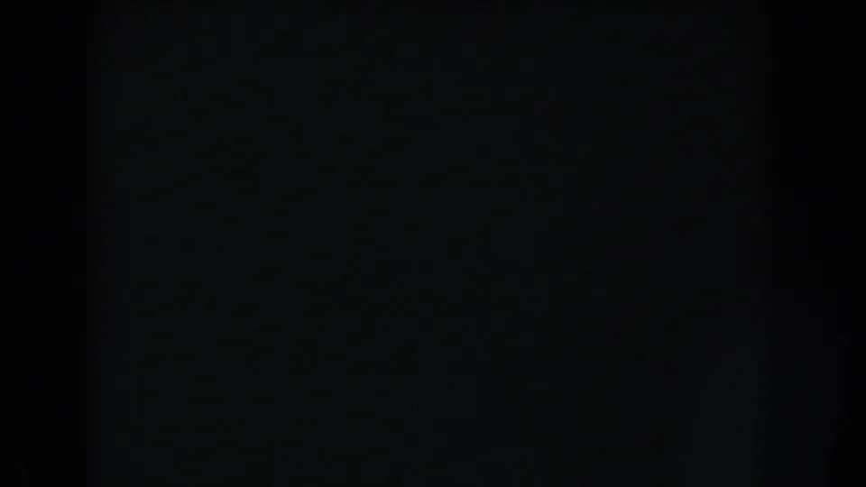 Dark 8mm frame with minimal tonal variation and no visible people, objects, landmarks, or text.