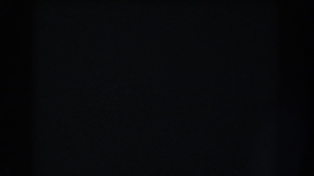 Mostly black 1960 Washington, DC 8mm frame with faint film grain, scratches, and minimal visible exterior detail.