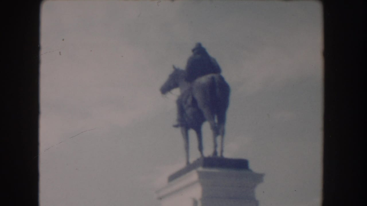 Equestrian statue on a pedestal against a pale sky.