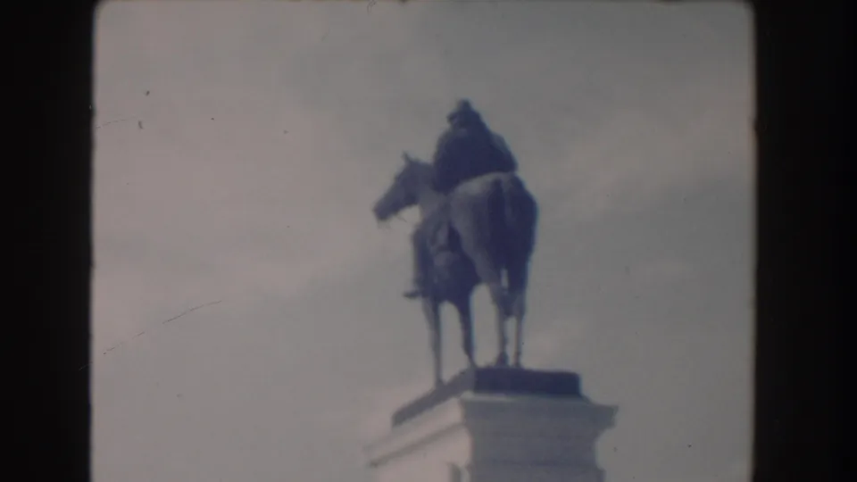 Washington DC frame showing an equestrian statue viewed from below, with the rider and horse silhouetted against a pale sky.