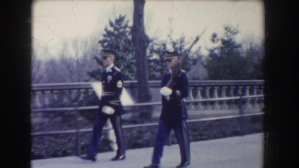 Two ceremonial guards continue past the camera in Washington, DC, with one carrying a rifle in circa-1960 footage.