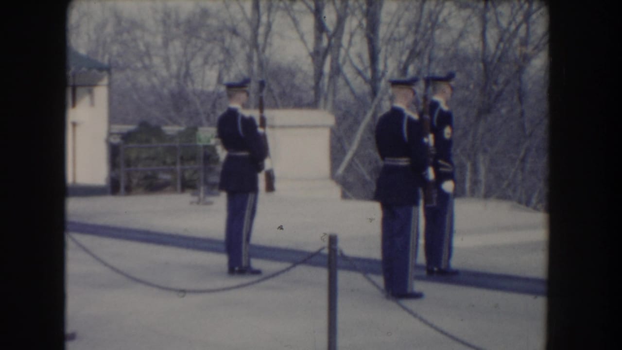 1960 Washington, DC frame showing uniformed guards positioned near the Tomb of the Unknown Soldier and public barrier.