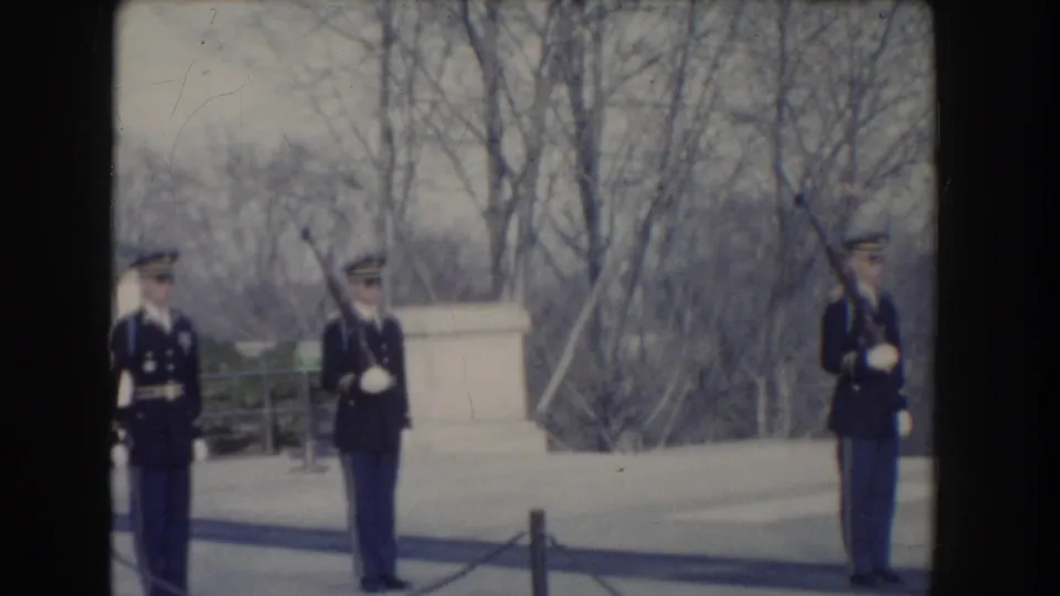 Washington, DC 1960 frame showing uniformed guards in a formal outdoor formation, filmed from a visitor distance.