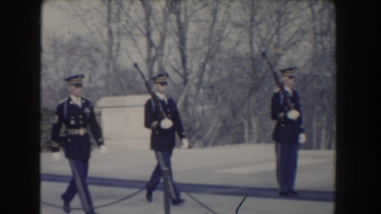 Three U.S. Army guards in dark dress uniforms march at the Tomb of the Unknown Soldier area in Washington, DC, circa 1960.
