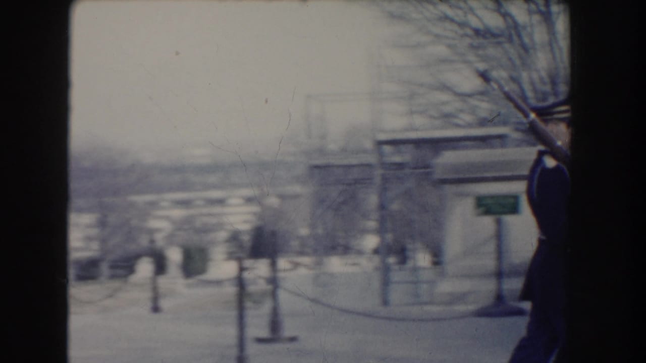 A uniformed soldier carrying a rifle with bayonet moves at the edge of the frame in Washington DC archival home-movie footage.