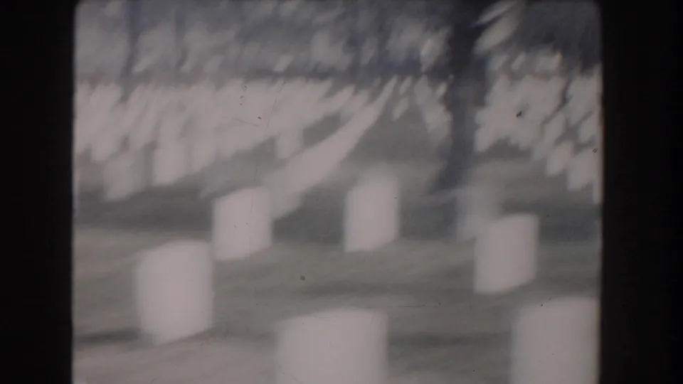 Soft, blurred 1960 8mm close pass across white cemetery headstones in Washington, DC.