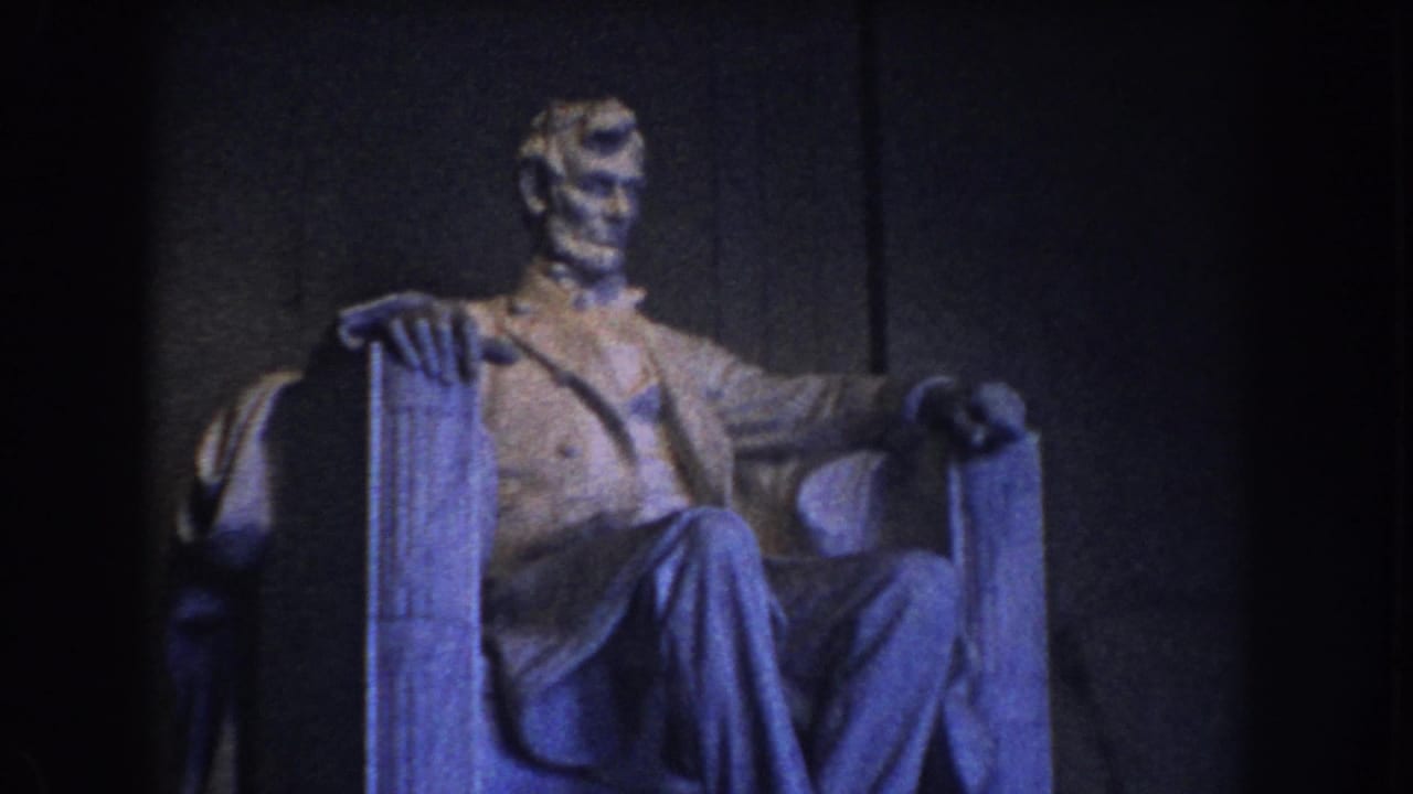 1960 Washington DC home-movie frame of the seated Lincoln statue in a dim interior with blue-purple color cast.
