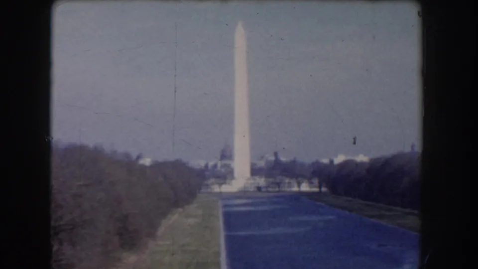 1960 Washington, DC view of the Washington Monument centered on the National Mall axis with winter trees and reflecting water.