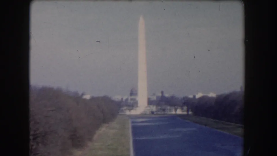 Washington, DC home-movie frame of the Washington Monument, Reflecting Pool, winter trees, and a distant domed building.