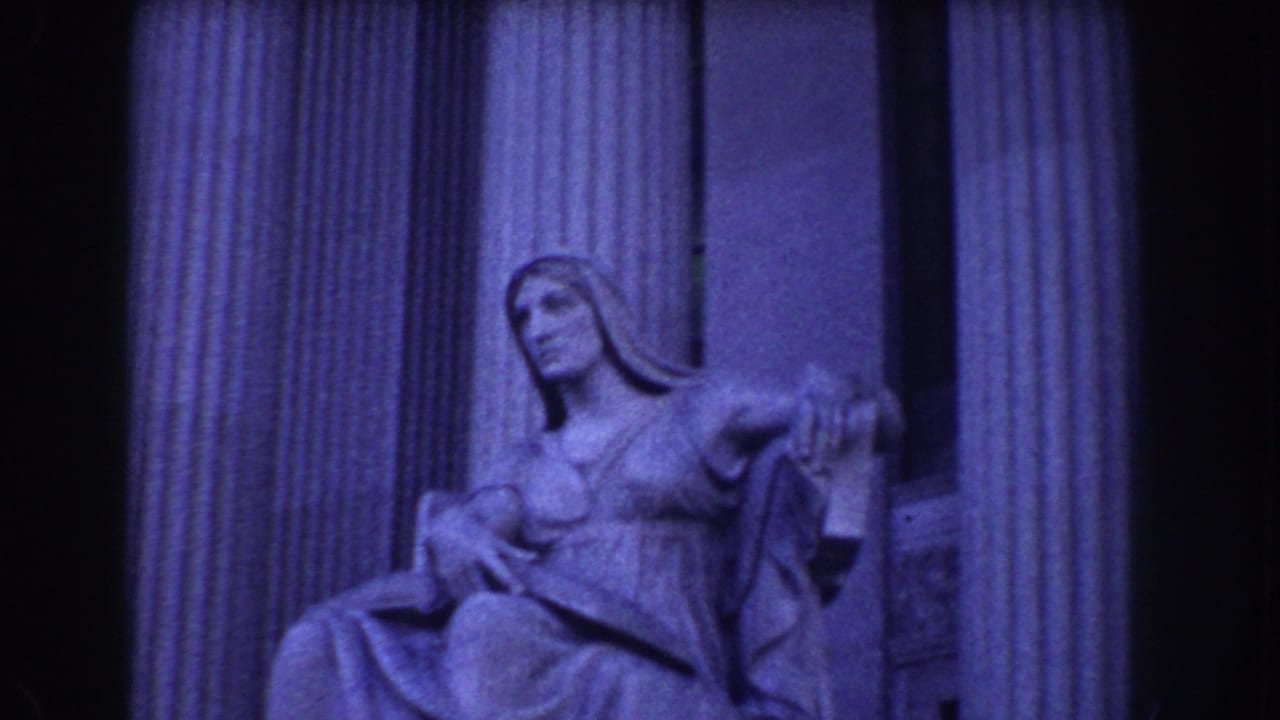 Seated stone statue framed between tall fluted columns.