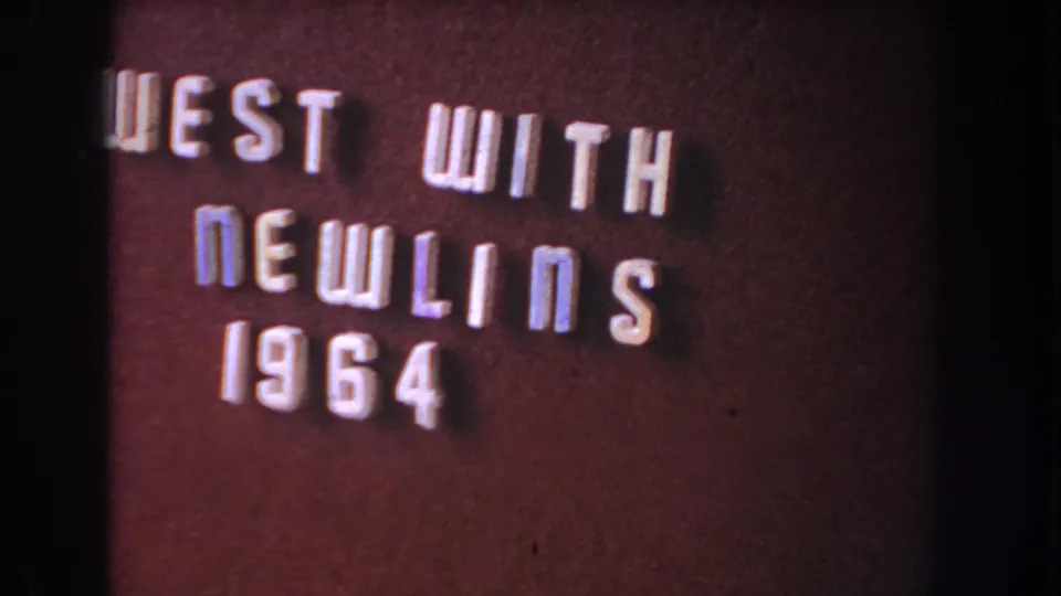 8mm home-movie title frame with the “WEST WITH NEWLINS 1964” lettering slightly cropped at the left edge.