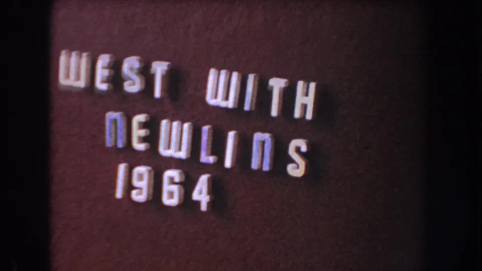 Final sampled 8mm frame of the burgundy title card, showing raised letters and visible gate-edge darkness.
