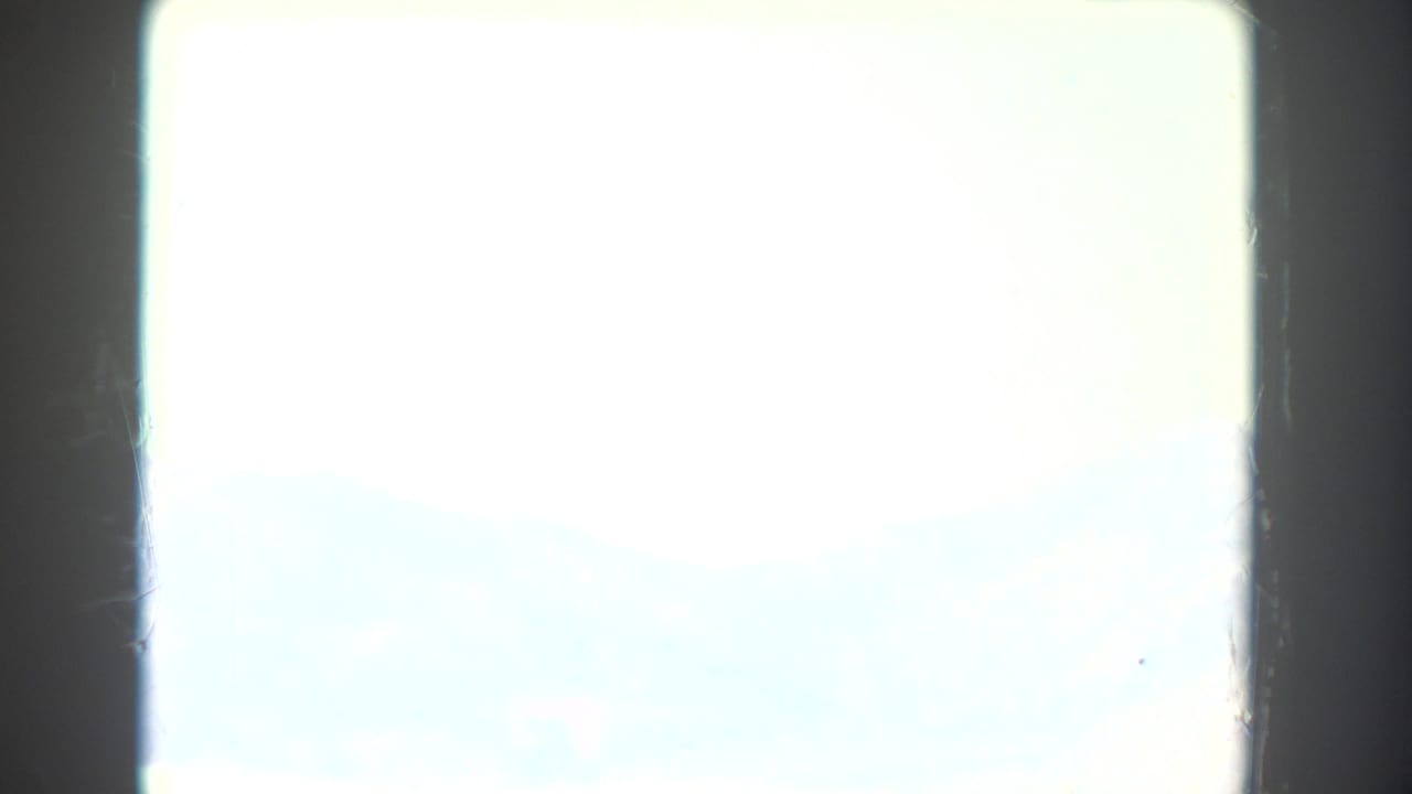 Overexposed bright frame with dark film borders and little visible landscape detail.
