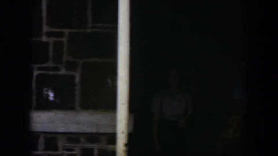 Dim 1951 Cuba 8mm frame showing a stone wall and doorway posts before the women are clearly visible.