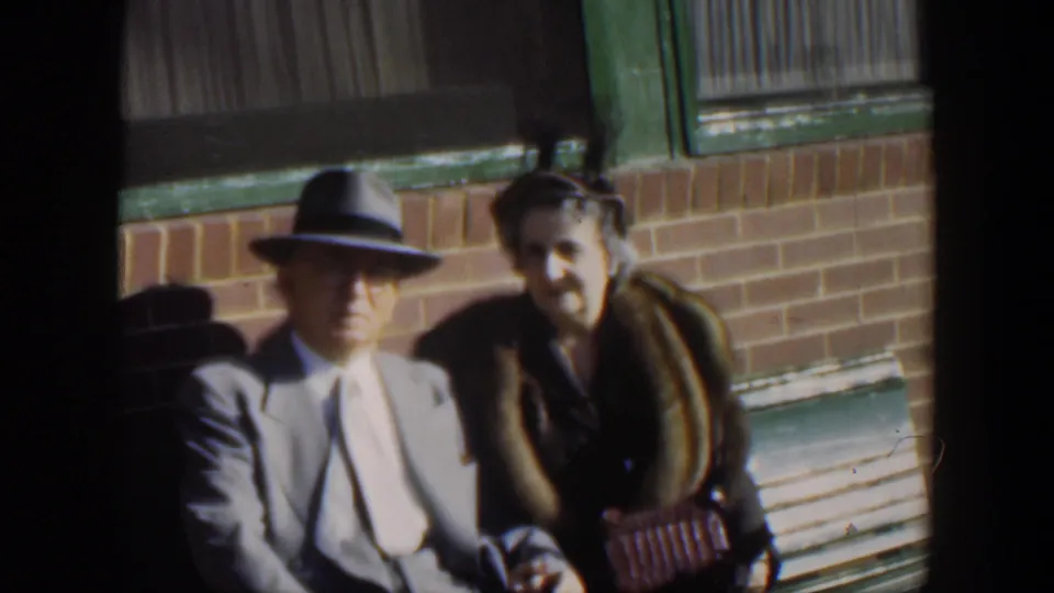 The final frame shows the couple still seated together outdoors, the man in a fedora and the woman in a fur-collared coat.