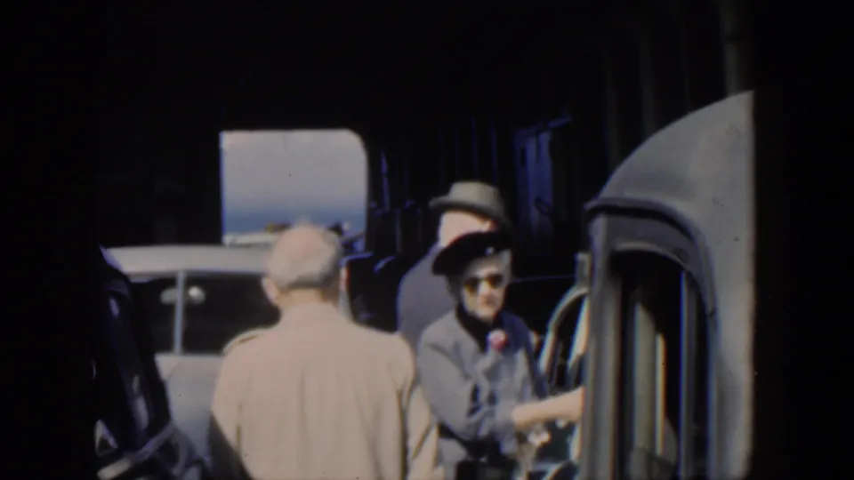 1951 Cuba frame with a woman in sunglasses by a classic car, surrounded by adults in hats and suits.