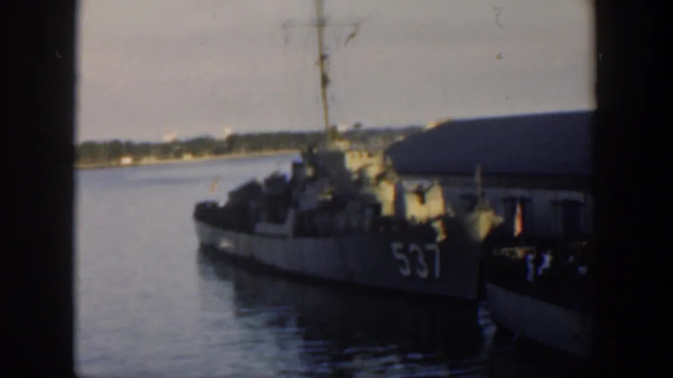 1951 Cuba 8mm frame showing the gray destroyer marked 537 moored beside a pier, softened by film blur and dark contact-frame borders.