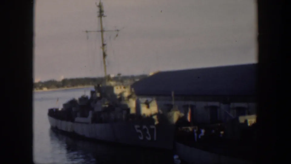 1951 Cuba frame showing a docked naval vessel marked 537 beside a harbor building, with small figures near the pier.