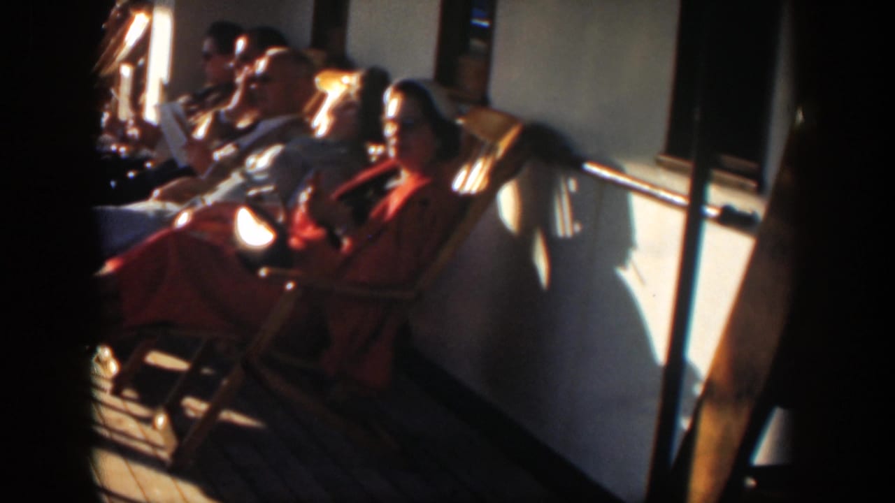 Passengers sit along a boat rail in warm sunlight.