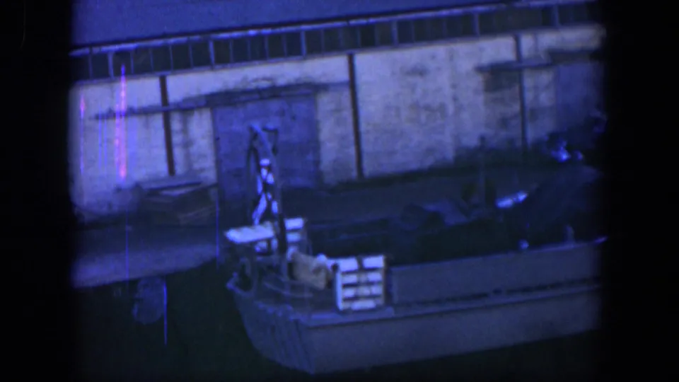 Cuba 1951 frame showing a small docked boat, crates, and waterfront wall as the sailors move out of view.