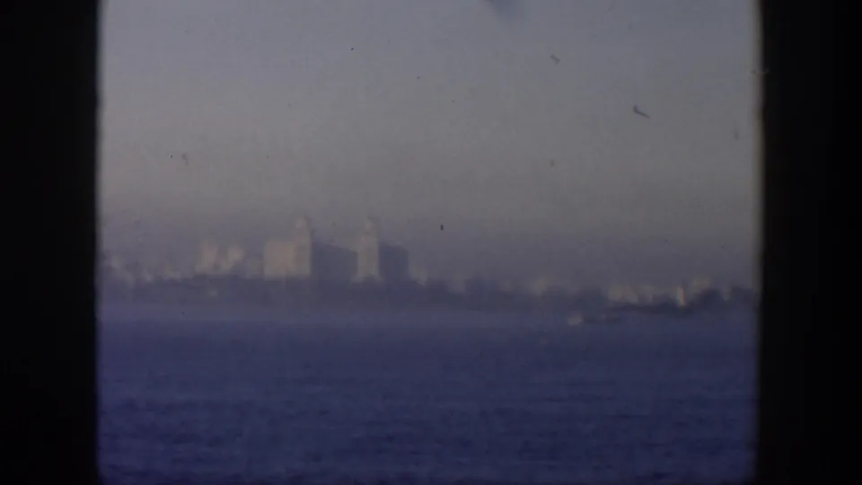 1951 Cuba view across water toward a faint coastal city skyline, with dark frame edges visible.