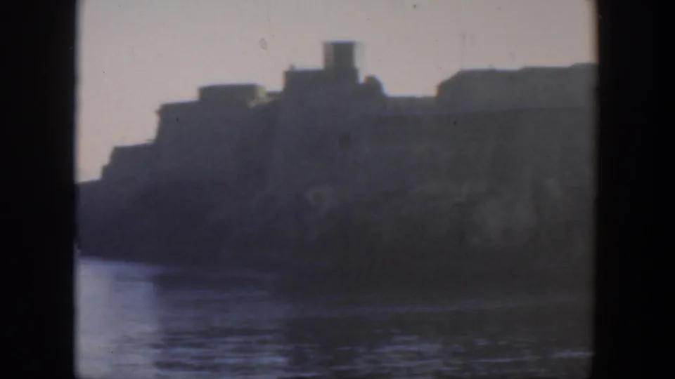 Soft 8mm frame of Cuba waterfront buildings near the shore, seen from across water in 1951.