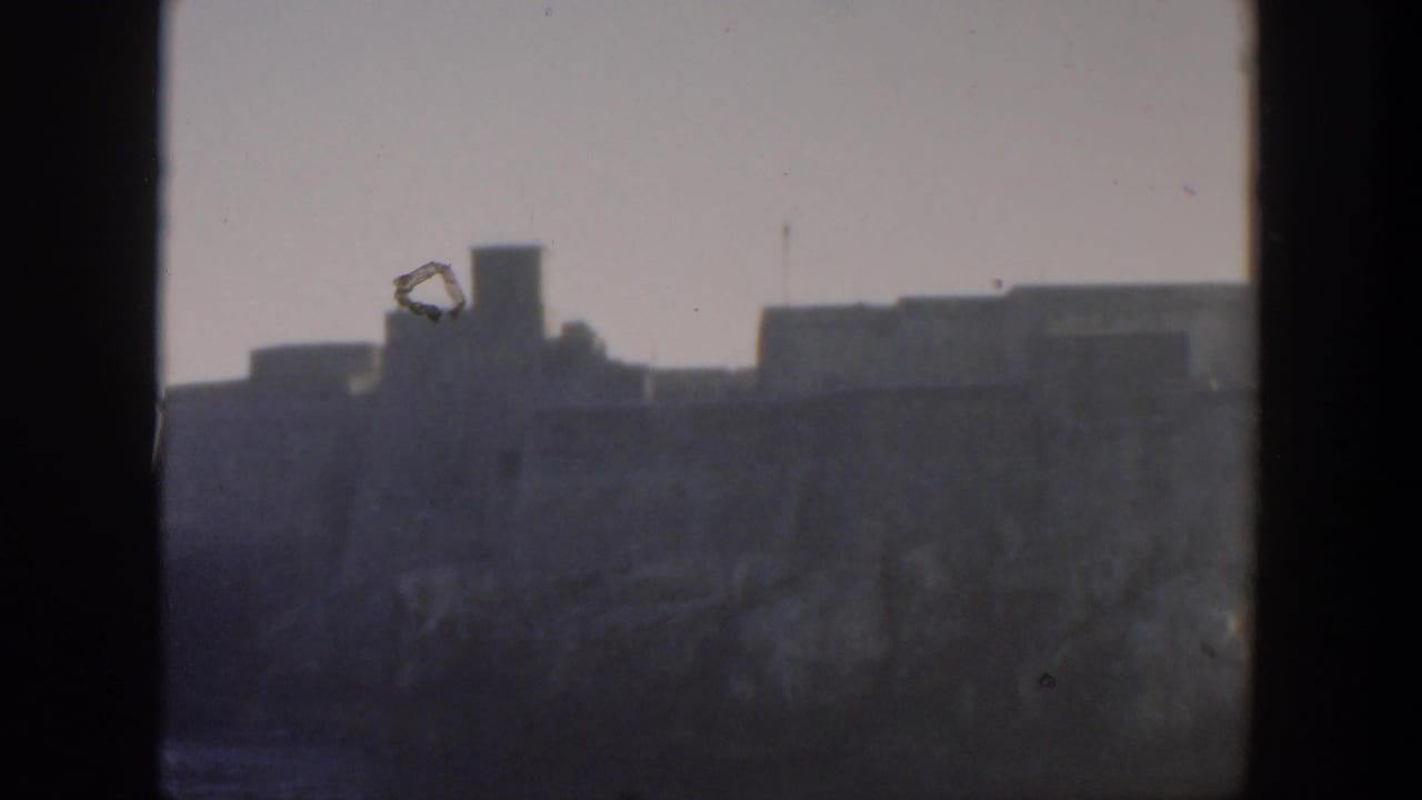 Soft distant fortress roofline behind a dark central frame bar.