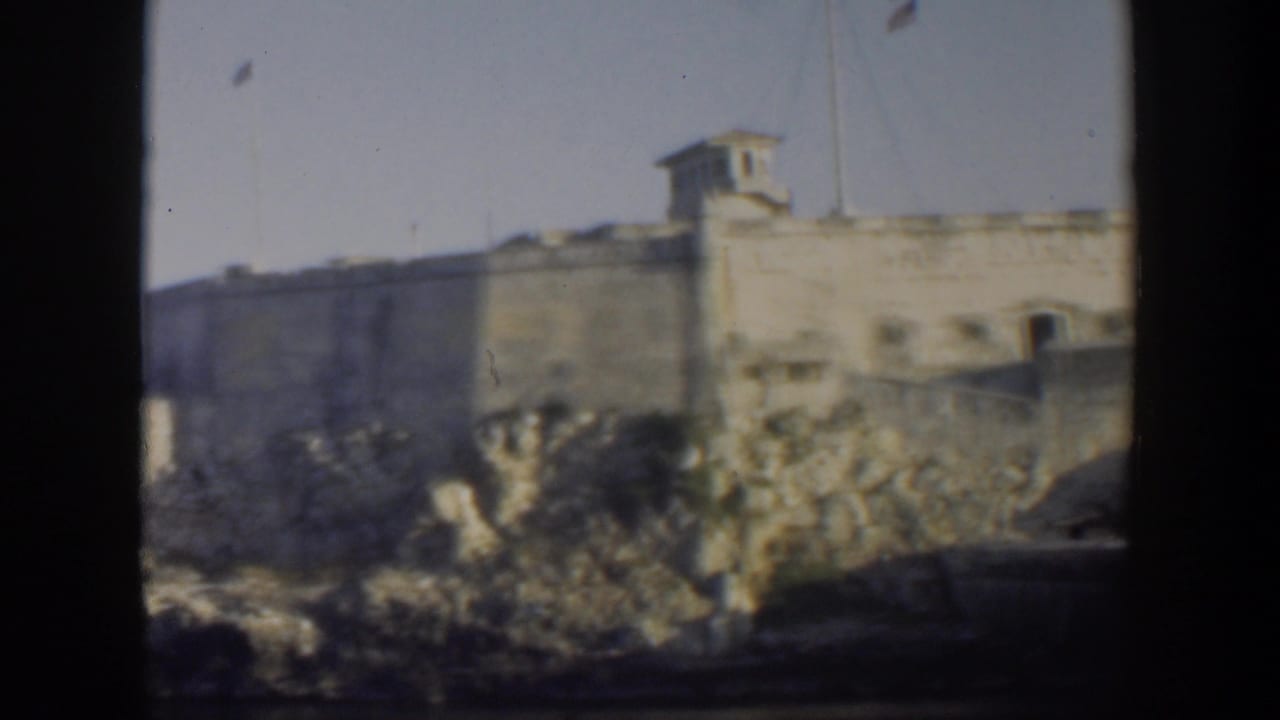 Fortress wall and rocky shoreline with water in the foreground.