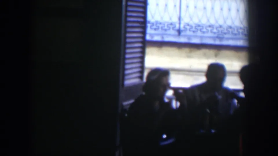 A shadowed 1951 Cuba street view shows silhouetted adults near a sunlit building facade with shutters and window bars.