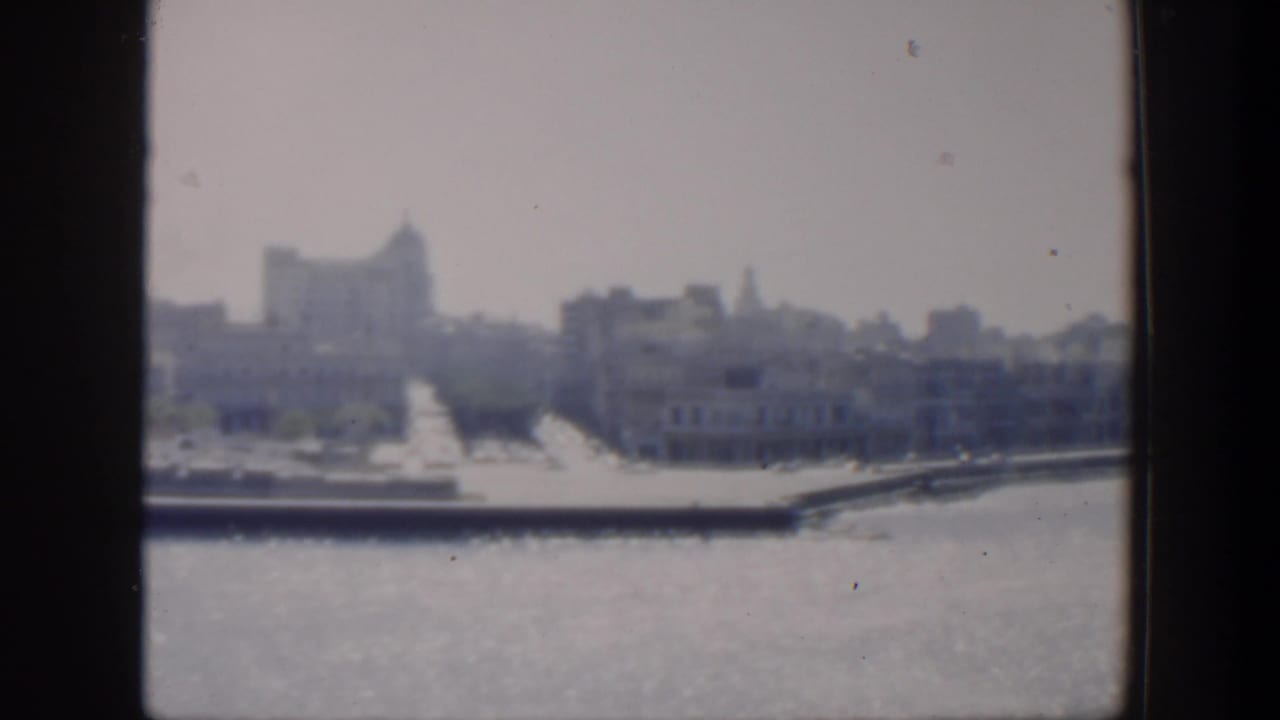 Distant skyline and waterfront seen across water in soft focus.