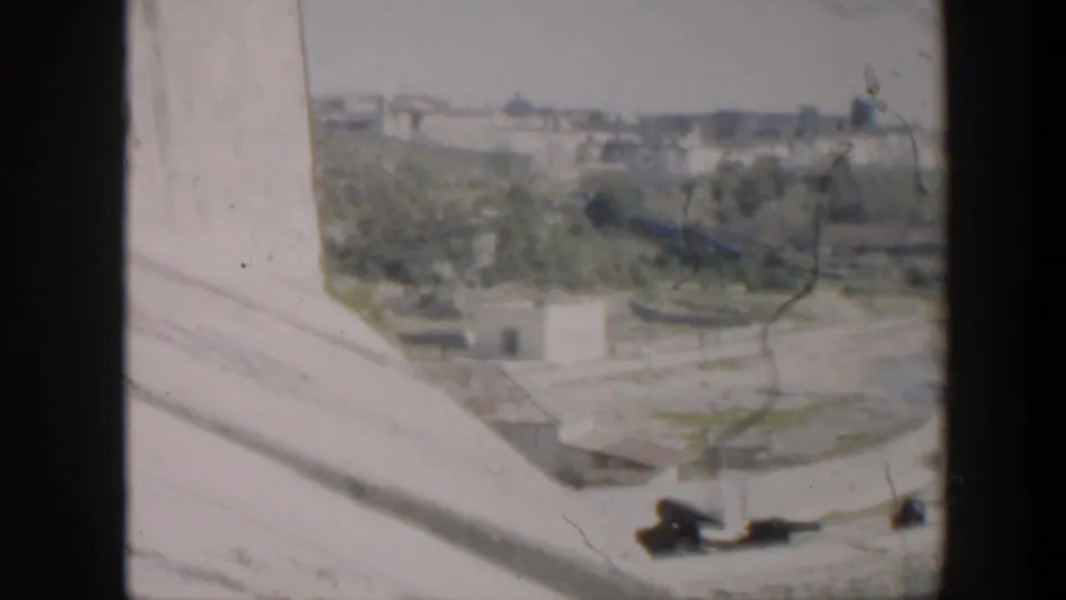 1951 Cuba home-movie view shifts to concrete edges, green planted areas, roads, and low waterfront buildings.