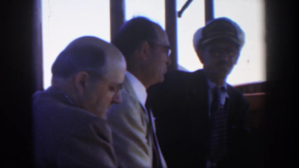 1951 Cuba vessel-cabin view with an older seated man, another man in a light suit, and a captain-like figure in a peaked cap.