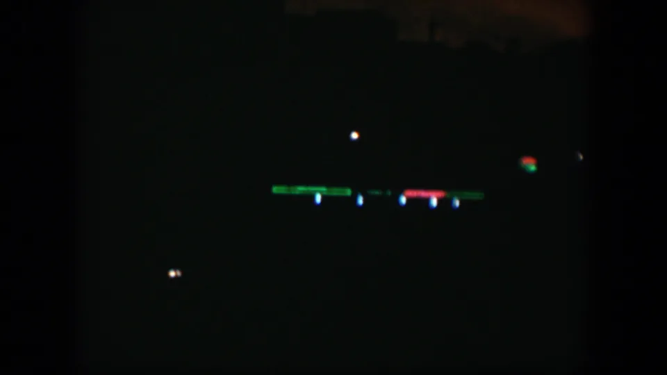 A dark 1951 Cuba night view with small green, red, and blue lights stretching across the distant background.