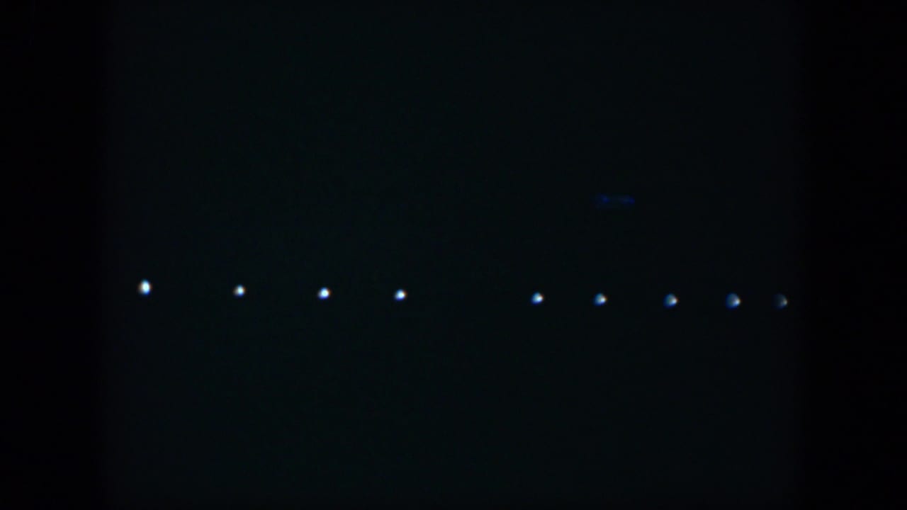 1951 Cuba 8mm frame showing small white lights arranged across a dark, underexposed night sky.
